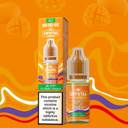 A product image featuring a 10ml bottle of Triple Mango SKE Crystal Nic Salt E Liquid, with a box in the background. The liquid is meant for use in vape devices and comes in a clear bottle with a label showing the flavor and nicotine strength.
