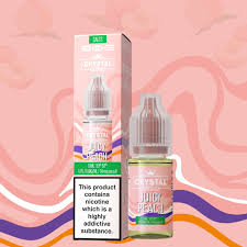 The image shows a box and a bottle of SKE Crystal Nic Salt E Liquid. The packaging is primarily pink and purple with product information and flavor visible.